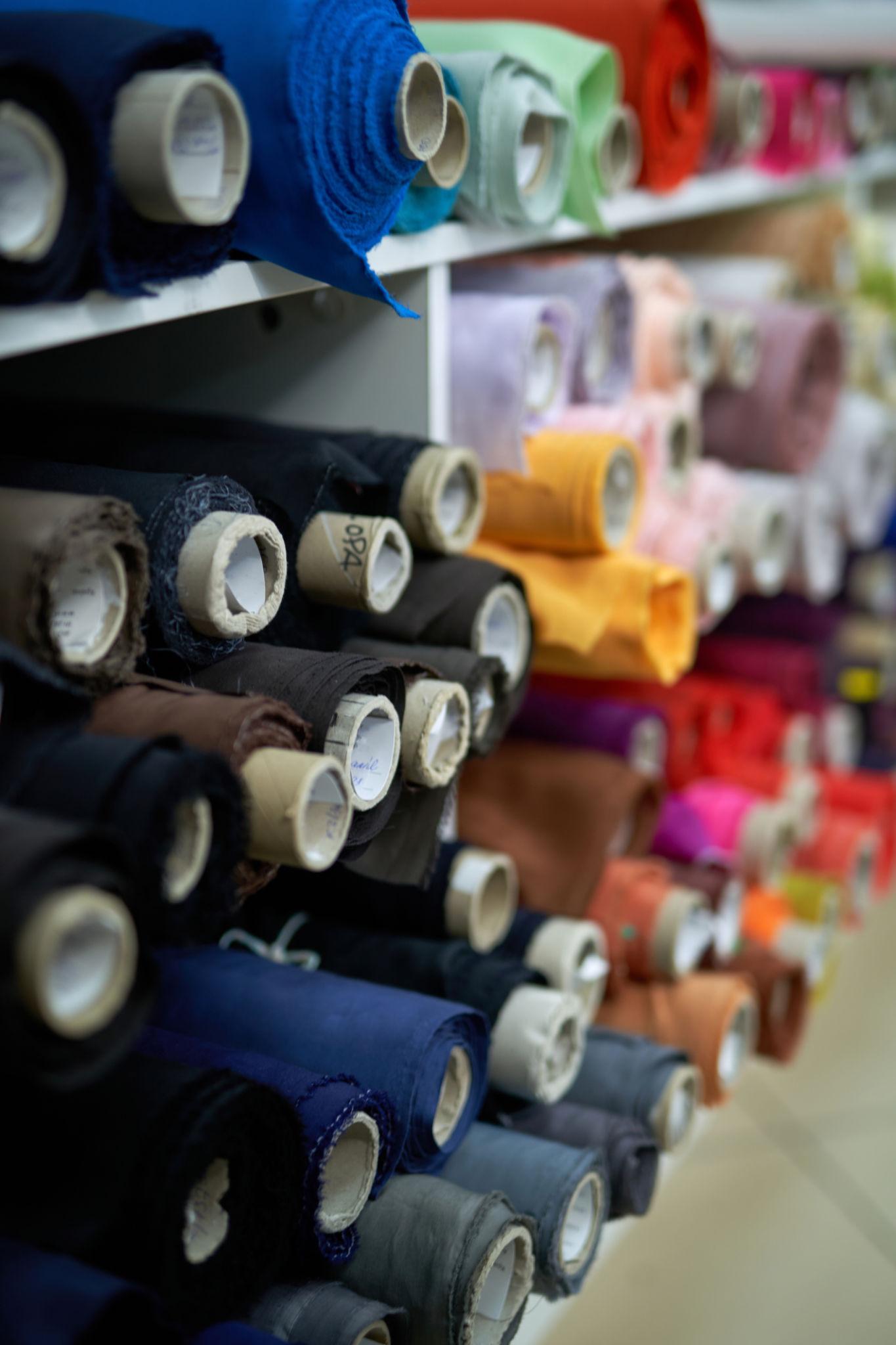 Rows of colorful fabric rolls in a textile studio