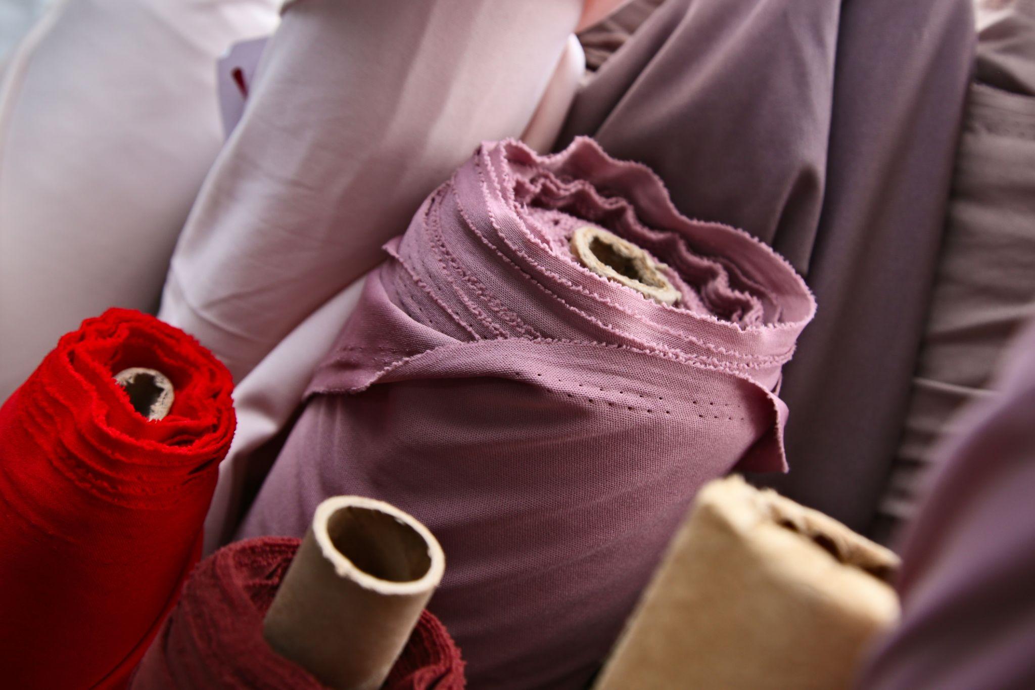 Close-up of layered fabric rolls in warm tones