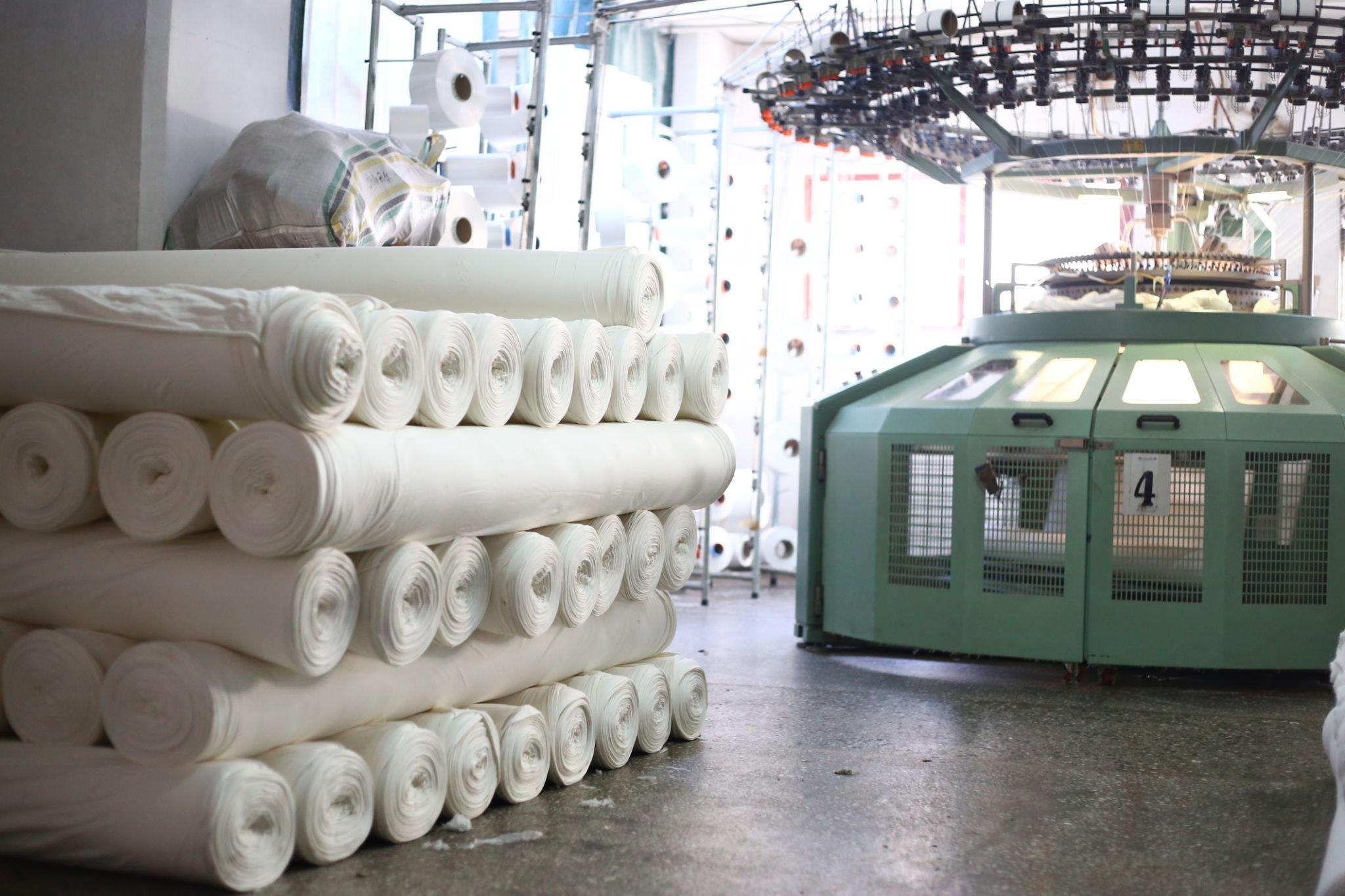 Fabric rolls and knitting machinery during fabric processing